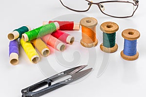 Colored thread with scissors on white background