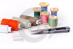 Colored thread with scissors on white background