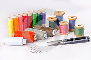 Colored thread with scissors on white background