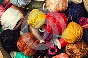 Colored thread spools and yarn balls in a close up view