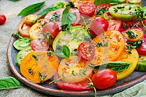 Colored tomato salad with onion and basil. Vegan food.