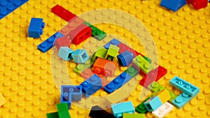 Colored toy bricks with Toy colorful letters on yellow background. Educational toy for children.