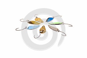 Colored trout fishing lures spoon lures for catching lake or rainbow trout, equipped with barbless hooks, on a uniform white bac