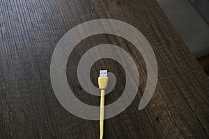 Colored USB type cable staying on dark wooden table.