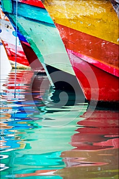 Colored water reflections . Colorful boats in the seaport .