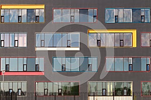 Colored windows of the building with the sky reflected in the glass. Geometric background. Building`s facade