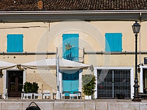 Colored windows of a house in the Porto Leonardesco canal of Cesenatico on a summer day, Emilia Romagna, Italy