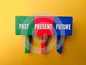 Colored wooden clips and wooden cube with the word PAST PRESENT FUTURE