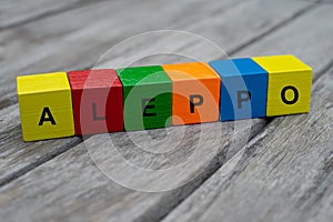 colored wooden cubes with letters. the word aleppo is displayed, abstract illustration