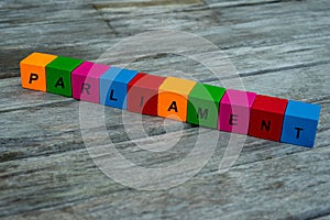 Colored wooden cubes with letters. the word parliament is displayed, abstract illustration