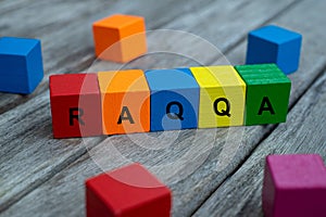 Colored wooden cubes with letters. the word raqqa is displayed, abstract illustration