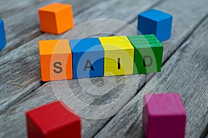 Colored wooden cubes with letters. the word said is displayed, abstract illustration
