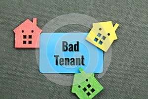 colored wooden houses and blue paper with the word bad tenant