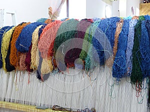 Colored wools supported on a weaving machine to make carpets in Uzbekistan.