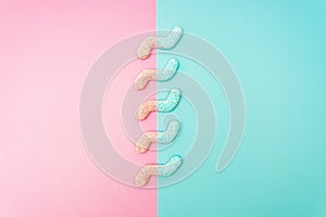 Colored z-shaped jelly worms on a contrast pink and blue background photo