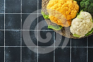 Colorfu cauliflower. Various sort of cauliflower on old stone tiles black concrete background. Purple, yellow, white and green col