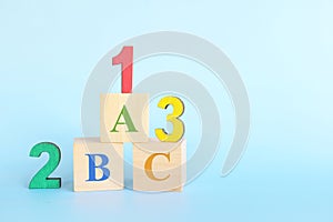 Colorful 123 numbers and abc letters alphabet on wooden blocks in blue background with copy space. Start of child or kid learning