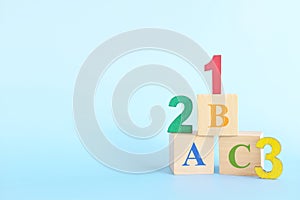 Colorful 123 numbers and abc letters alphabet on wooden blocks in blue background with copy space. Start of child or kid learning