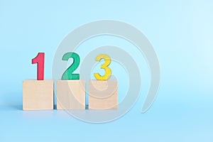 Colorful 123 numbers on wooden blocks in blue background with copy space. Start of child or kid learning counting concept.
