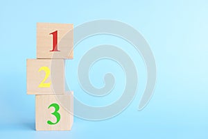 Colorful 123 numbers on wooden blocks in blue background with copy space. Start of child or kid learning counting concept.