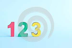 Colorful 123 numbers on wooden blocks in blue background with copy space. Start of child or kid learning counting concept.