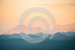 Colorful, abstract double exposure of mountains in sunrise. Minimalist scenery with color gradients.