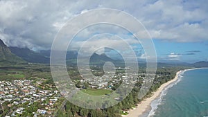 Colorful aerial view of rocky mountains. A tropical beach with turquoise blue ocean water and waves lapping on a hidden