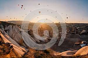 Colorful air balloons flying over Cappadocia landscape at sunris