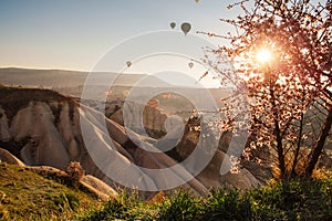 Colorful air balloons flying over Cappadocia landscape at sunrise