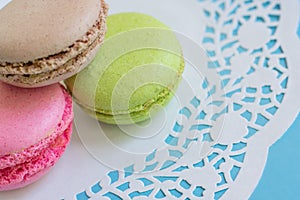 Colorful almond macarons on white napkin on blue background. French pastry sweet cookies