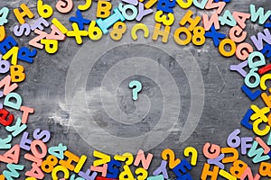 Colorful alphabet letters on gray background question mark and space for text, top view