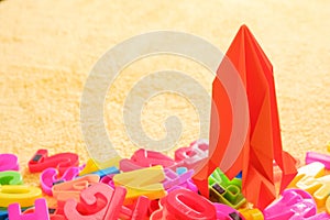 Colorful alphabet letters with red toy origami rocket. Education concept