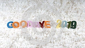 Colorful alphabets spelled `Goodbye 2019` on furry carpet.