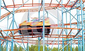 Colorful amusement park ride car going fast by with full speed.