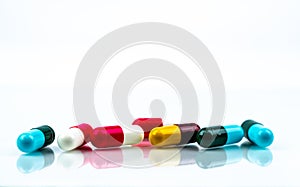 Colorful antibiotic capsule pills on white background. Pharmaceutics concept. Antibiotic drug resistance. Pharmaceutical industry.