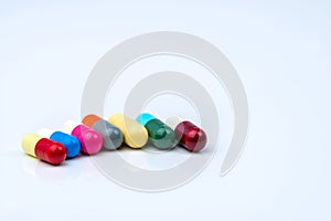 Colorful of antibiotic capsules pills in a row on white background with copy space.