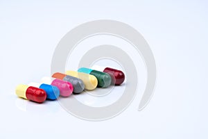 Colorful of antibiotic capsules pills in a row on white background with copy space.