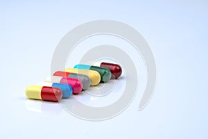 Colorful of antibiotic capsules pills in a row on white background with copy space