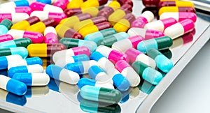 Colorful of antibiotic capsules pills with shadows on stainless steel drug tray
