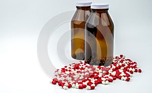 Colorful of antibiotic capsules pills with two amber glass bottles on white background.