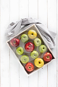 Colorful apples in a wood tray top view