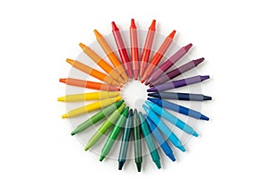 Colorful array of crayons arranged in a circular pattern on a white