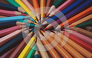 Colorful art pencils arranged in a circle on a table