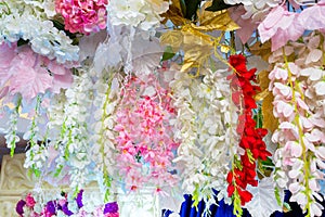 Colorful artificial paper flowers hanging on a stage.