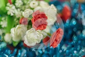 Colorful artificial rose flowers on blue bokeh background