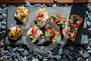 Colorful Assorted Canap s On Slate Bed Outdoors With Fresh Tomatoes, Cheese, and Herbs