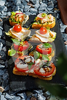 Colorful Assorted Canap s On Slate Bed Outdoors With Fresh Tomatoes, Cheese, and Herbs