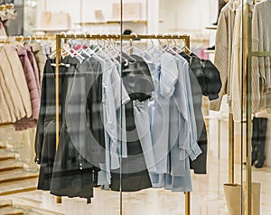 Colorful assortment of casual youth women's clothes. Rack At Store. Blurred View through shop window. Seasonal sale