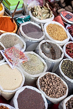 Colorful assortment of powdered spices and seasonings at traditional market at Goa. Whole and grounded flavorings sold.