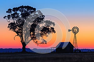 Colorful Australian outback sunset with a windmill.